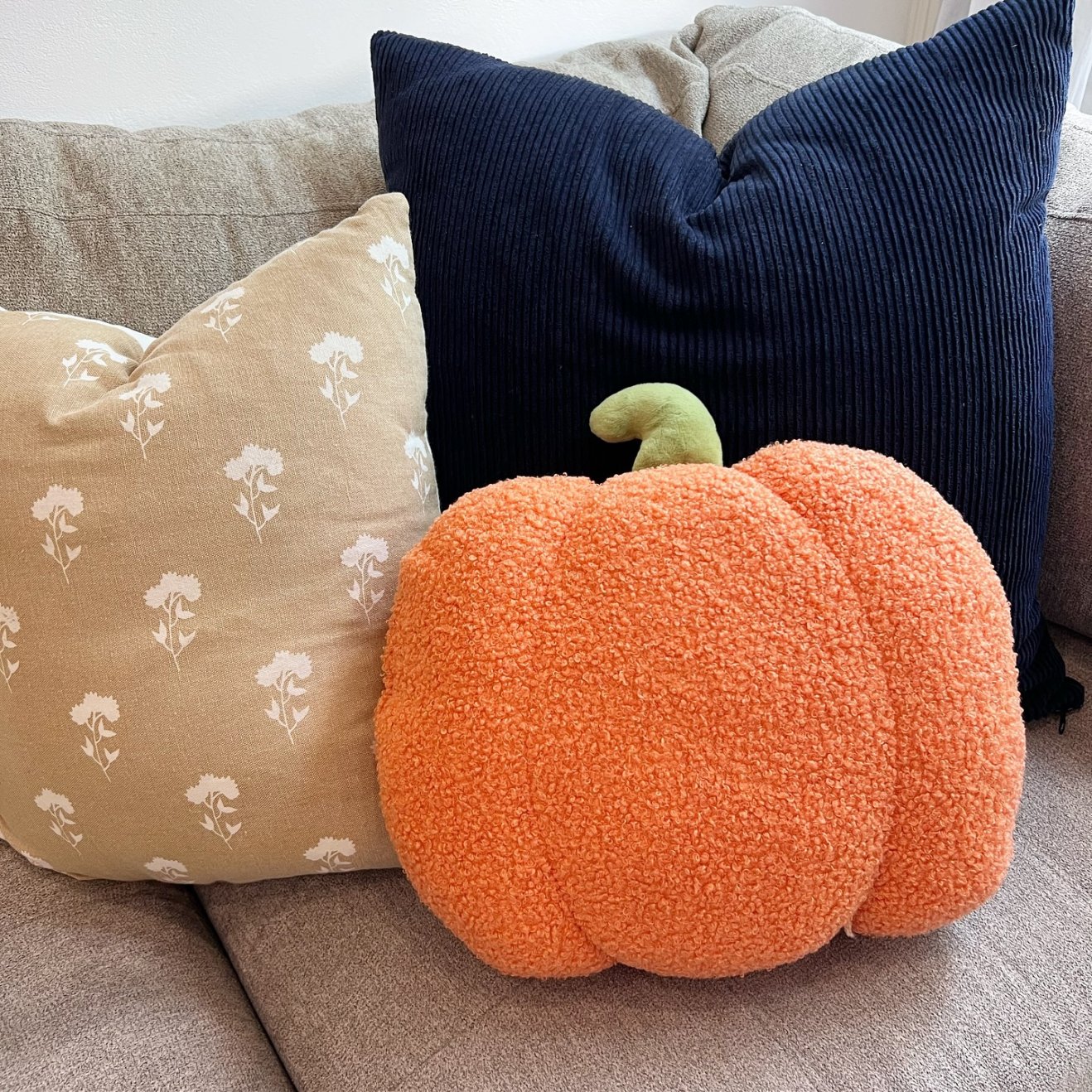 a set of pillows with a pumpkin pillow in the middle